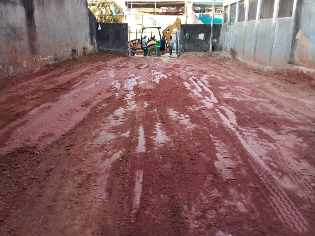Terreno urbano preparado com retroescavadeira ao fundo